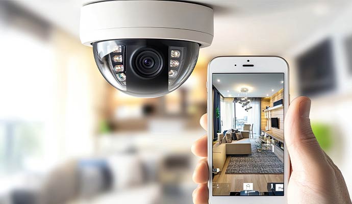 Ceiling-mounted dome camera with mobile app displaying living room feed
