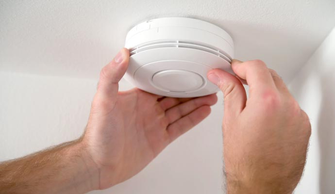 Person installing smoke detector system