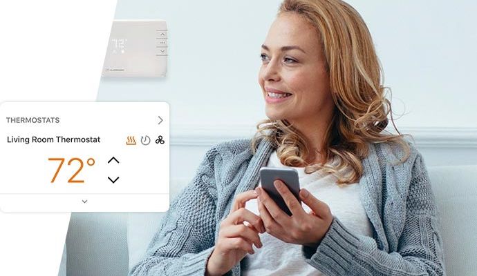 A person controlling thermostat using smartphone