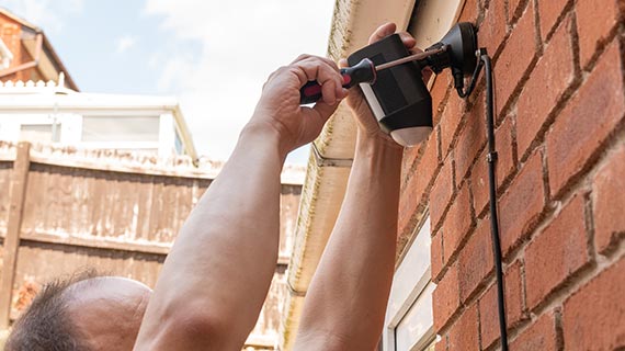 technician installing floodlight camera