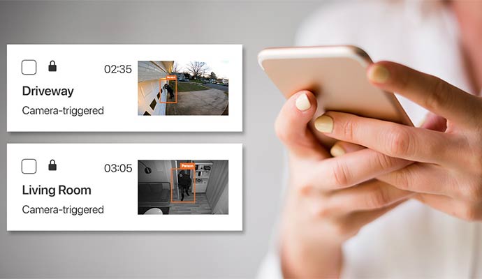 Close up of a person holding a smartphone showing real-time security camera motion alerts